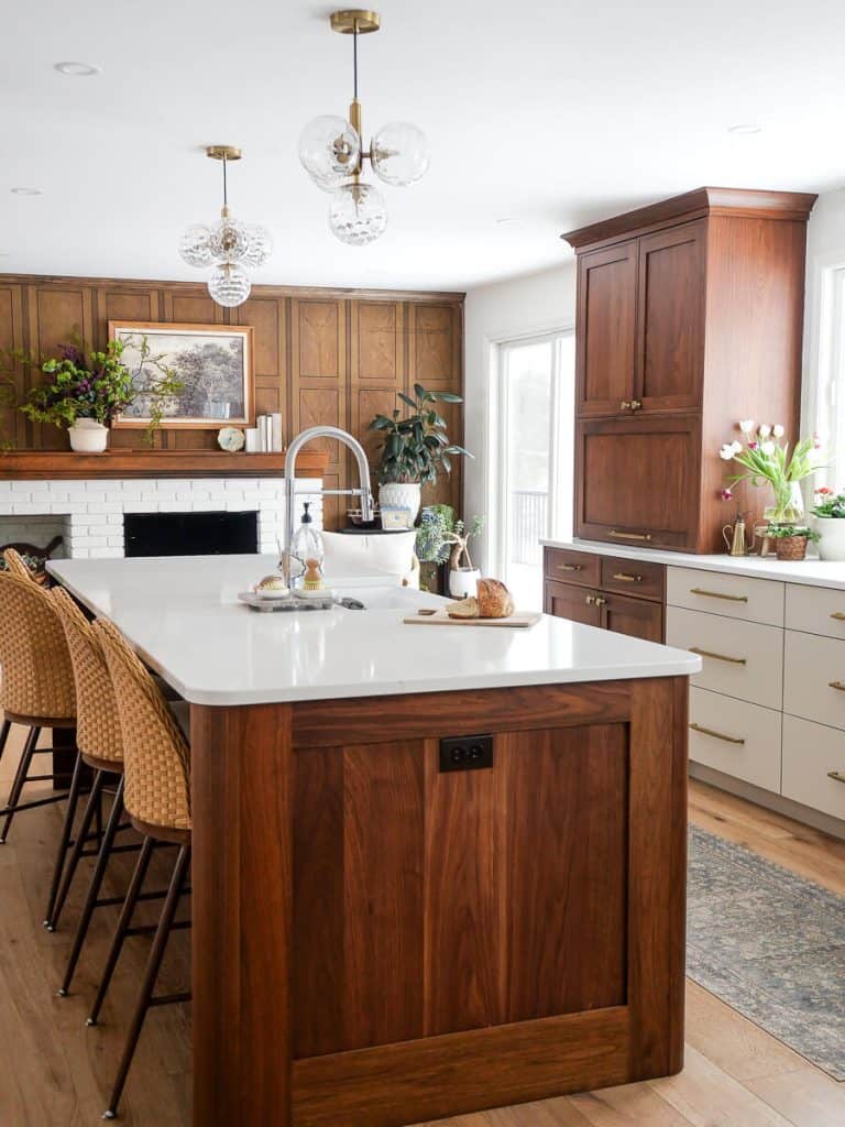 Large central walnut island in a kitchen with a fireplace.