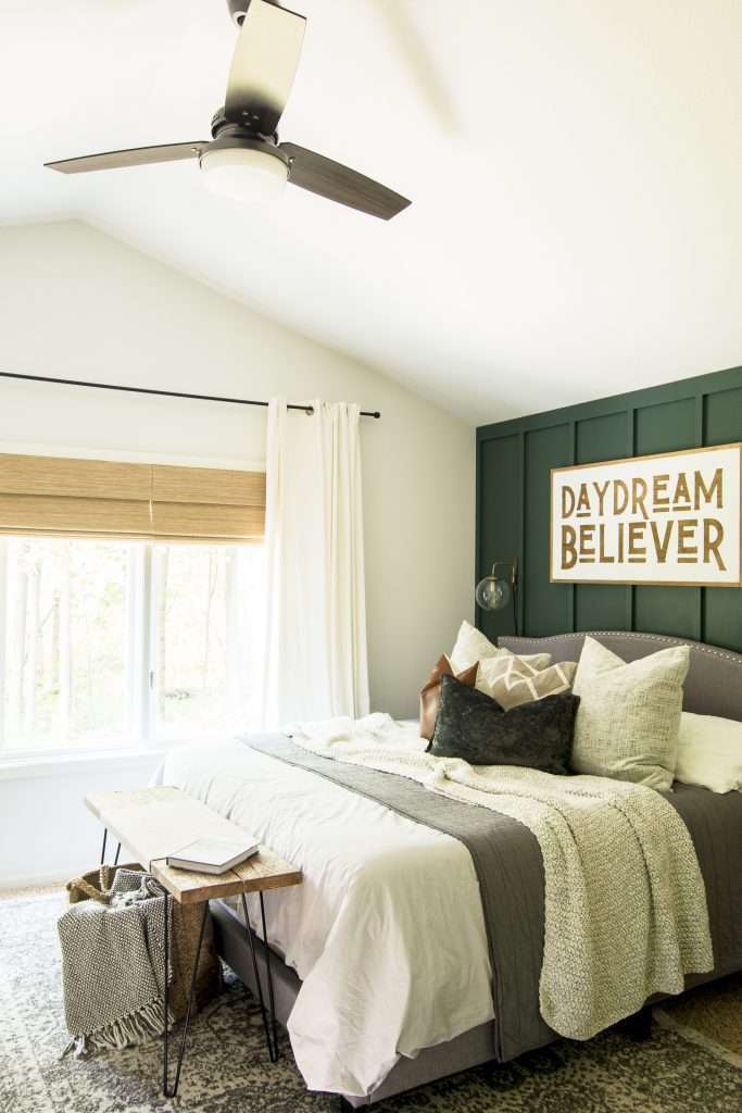 Green accent wall in a bedroom.