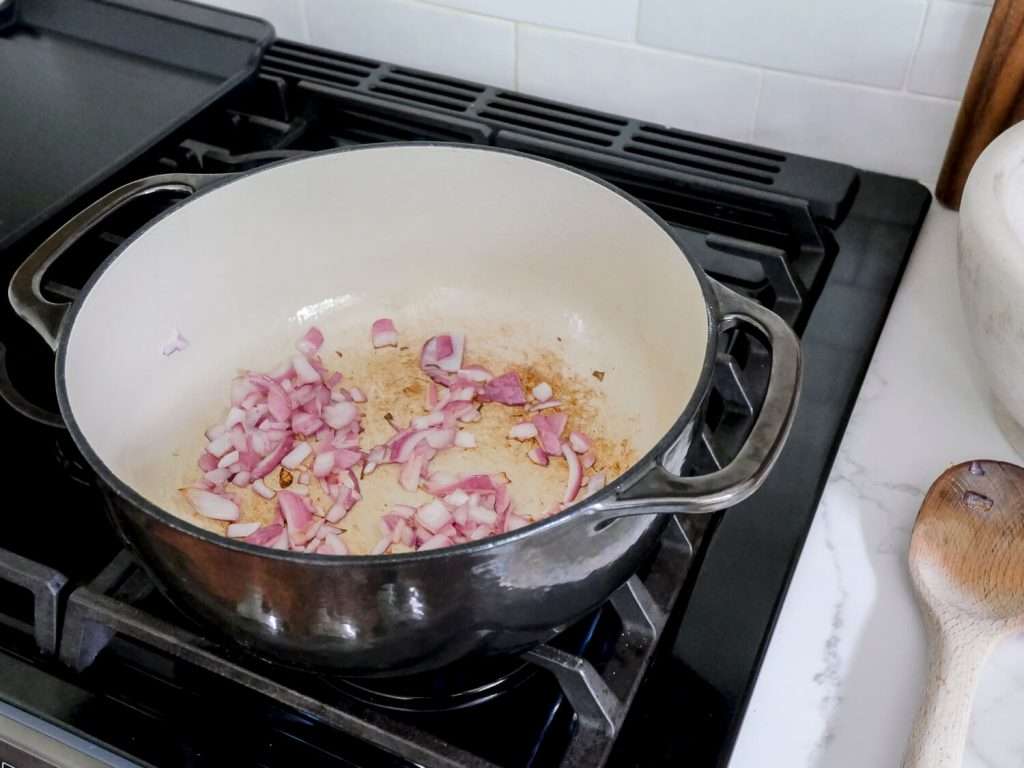 red onions cooking in a dutch oven