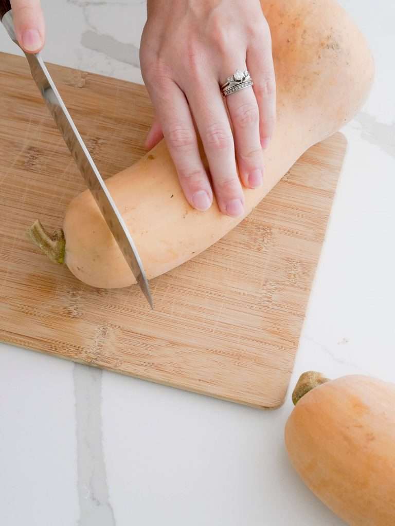Cutting off the top of a butternut squash.