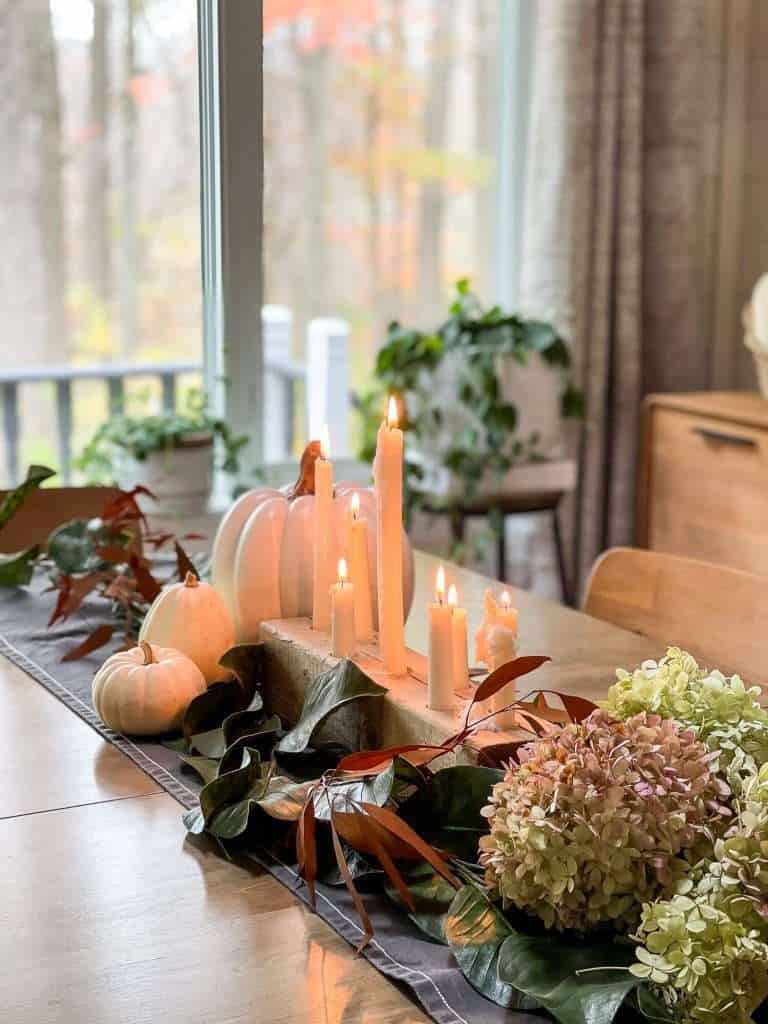 Candle table centerpiece with pumpkins.
