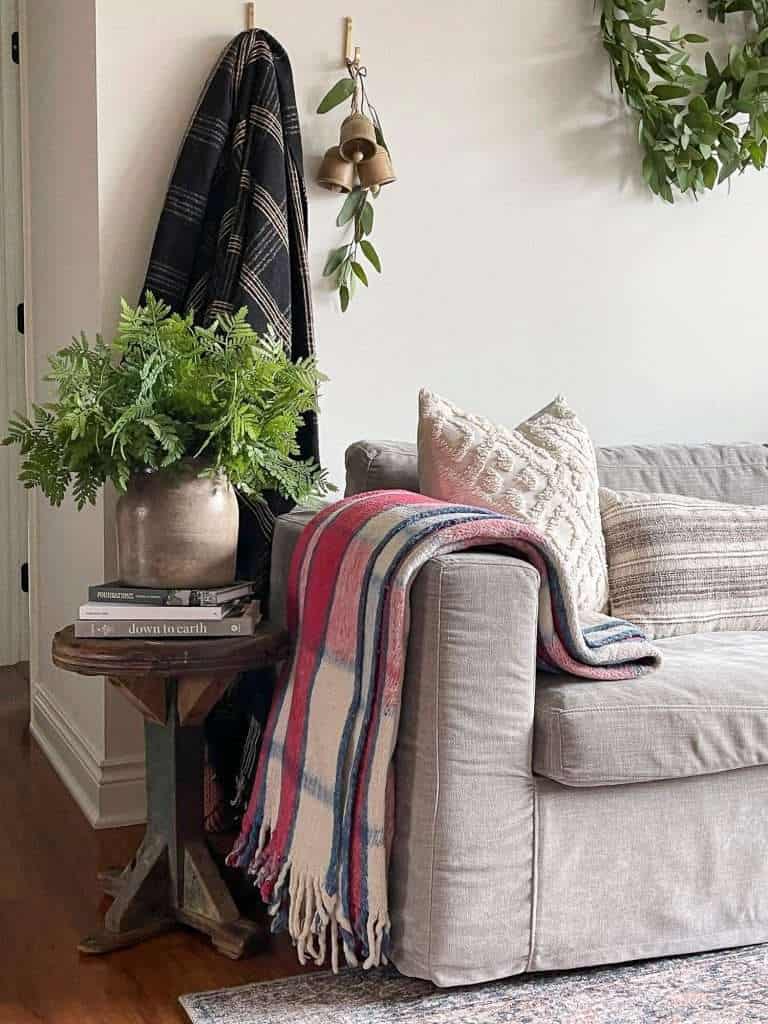 Organic modern interior design with a blanket and side table.