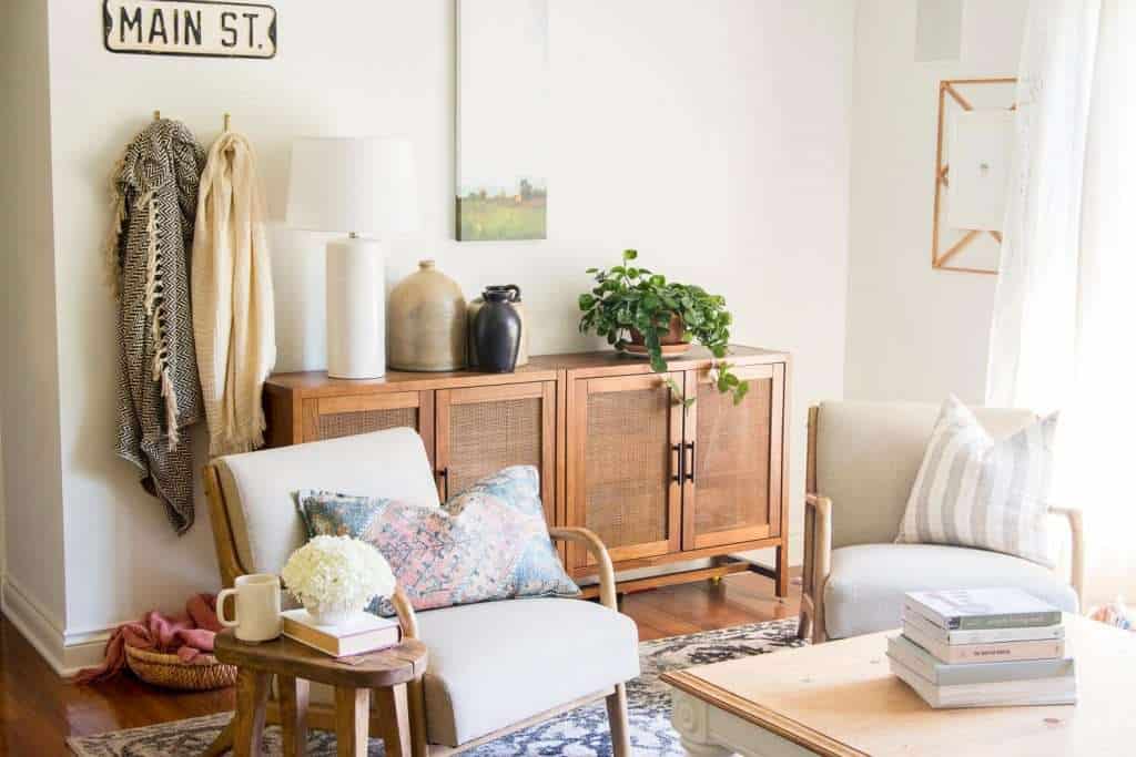 Living room chairs layered in front of a cabinet.