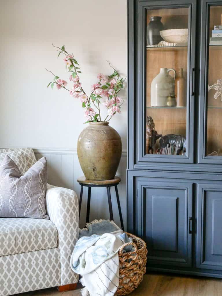 Black cabinet with antiques on the shelves.