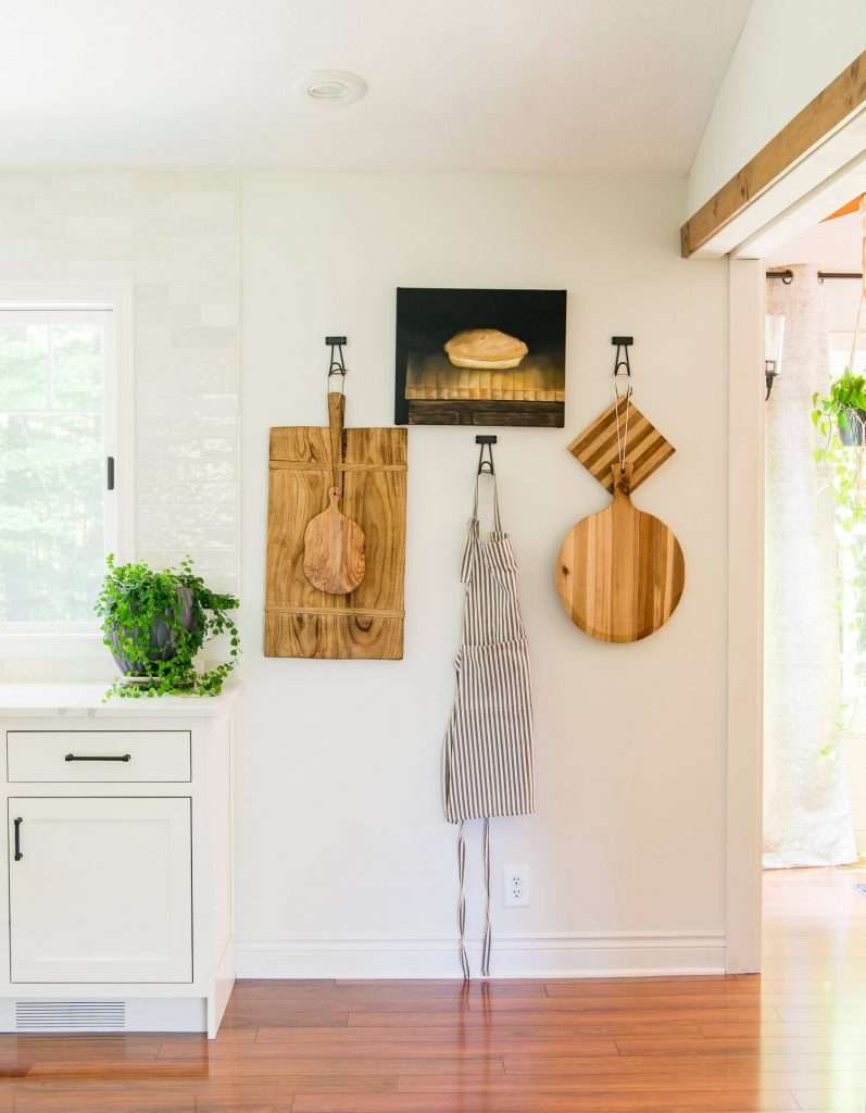 Kitchen wall with cutting boards and a ficus repens.