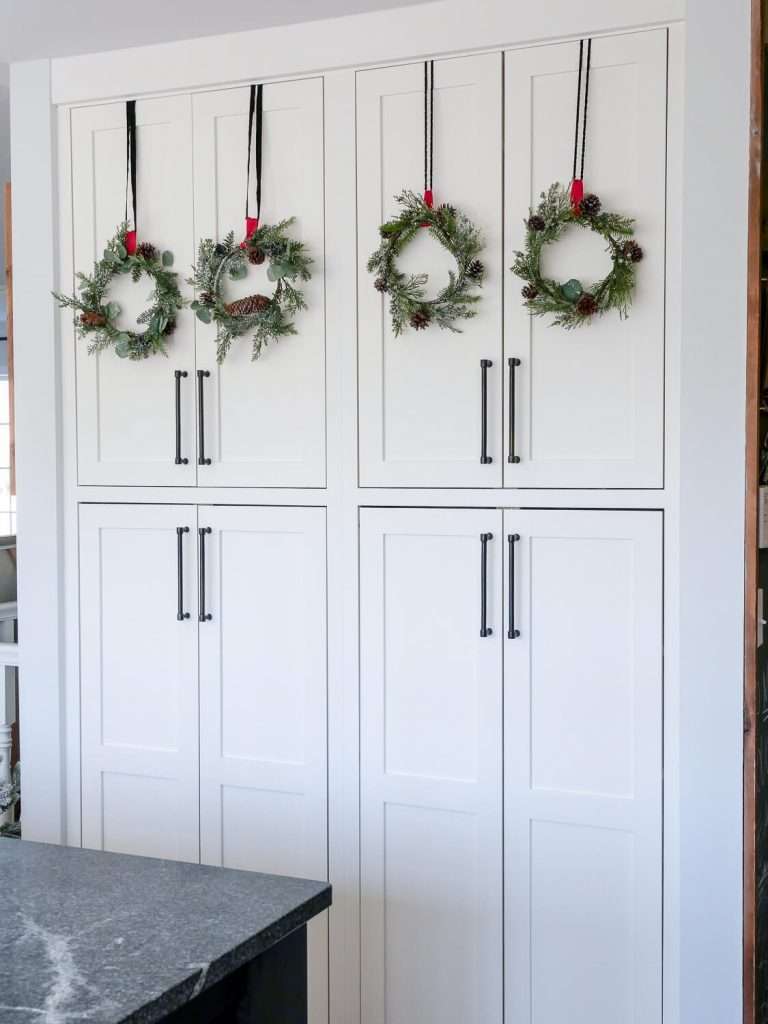 Pantry doors with wreaths and ribbon.