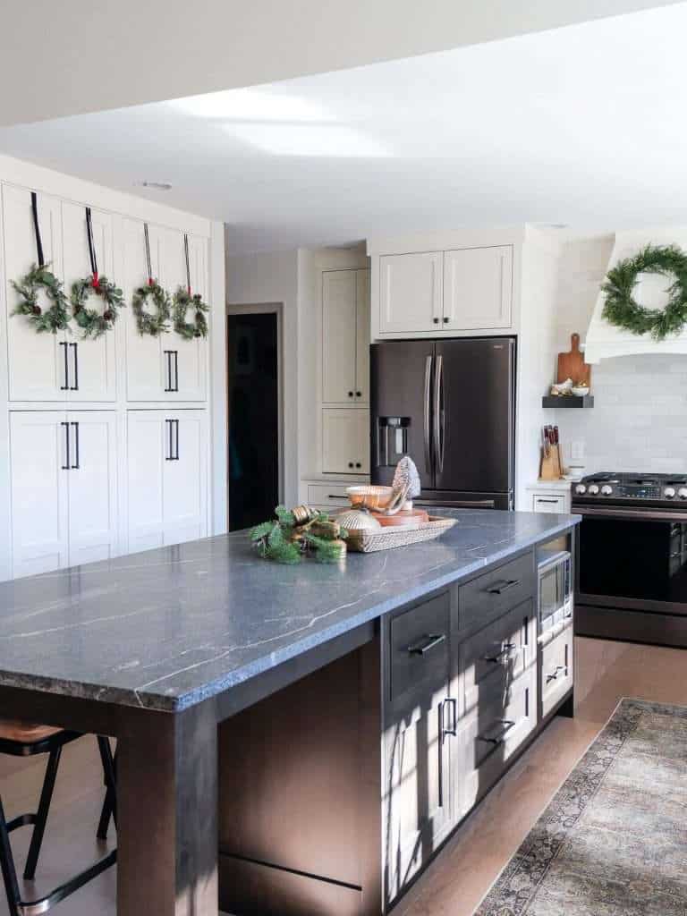 Kitchen island with wreaths on cabinetry.