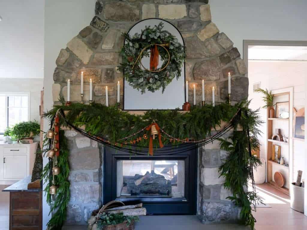 Christmas mantel decorated with garland and candles.