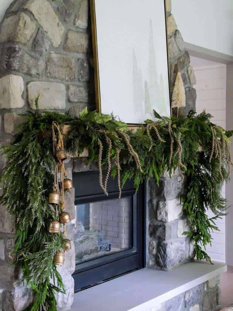 Stone fireplace showing how to hang garland on a mantel.