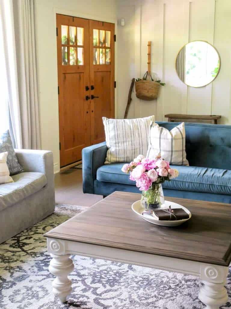 Blue velvet sofa in a living room with transitional farmhouse decor.