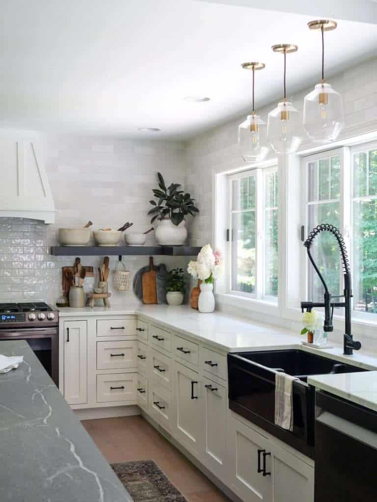 Black farmhouse kitchen sink against white quartz countertops.