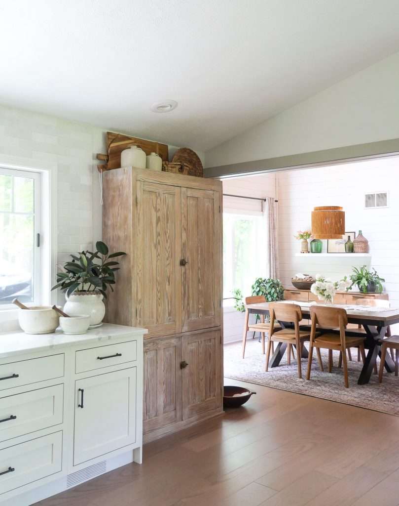 Wood kitchen cabinet looking into dining room.