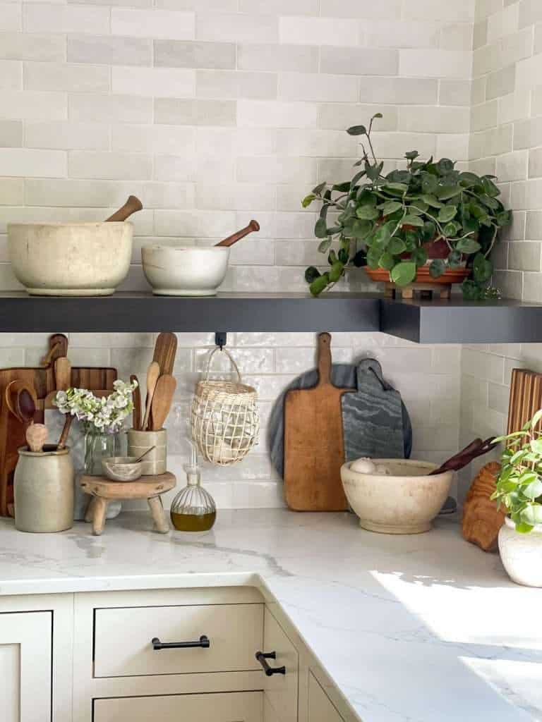 Corner of a kitchen with tile backsplash and white quartz countertops.