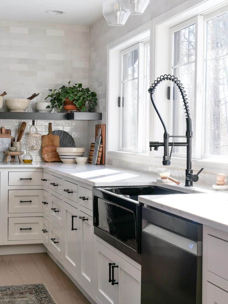Black faucet and apron sink in a kitchen
