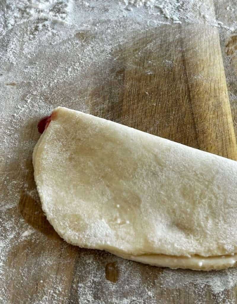 Folding dough over for fruit empanadas.