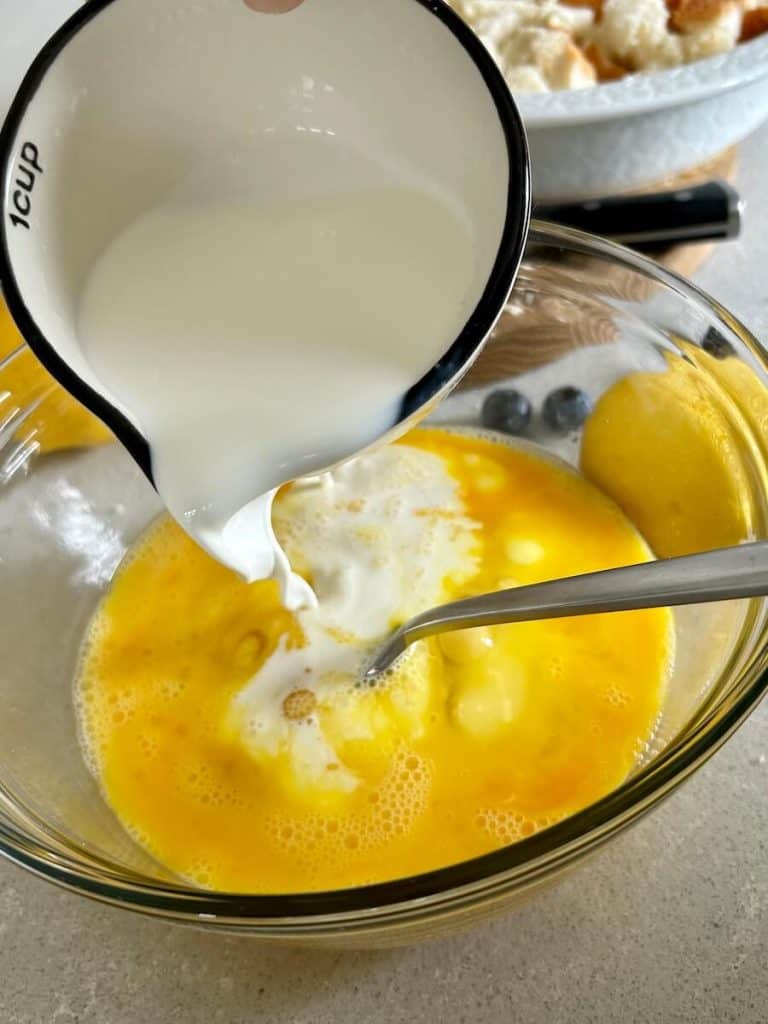 Adding cream to eggs.
