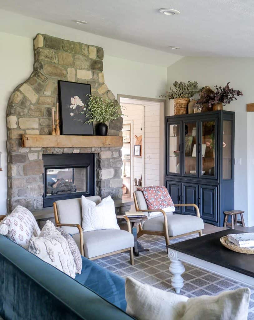 Mix matched decor with a stone fireplace and velvet sofa.