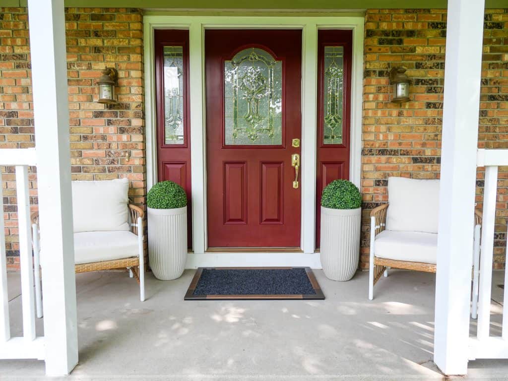 Front porch decorated with chairs and planters.