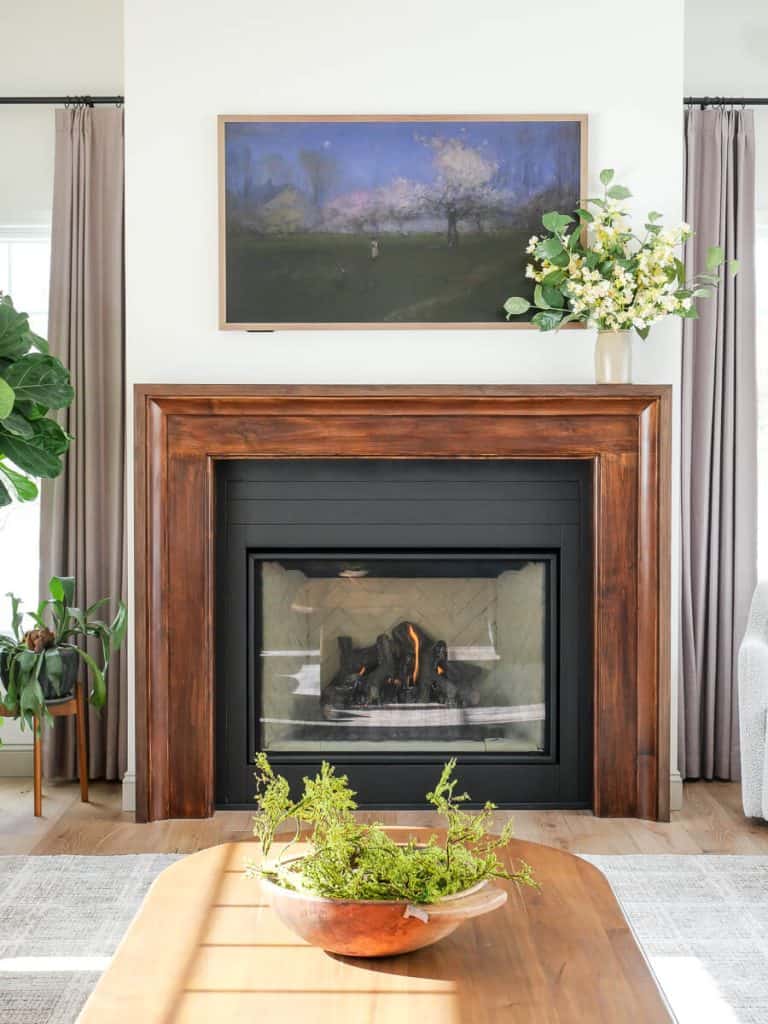 Fireplace mantel with bouquet of faux flowers.