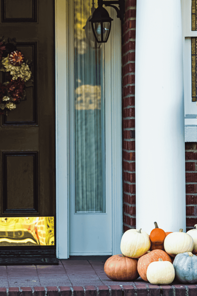 Pile of pumpkins on a fall front porch.