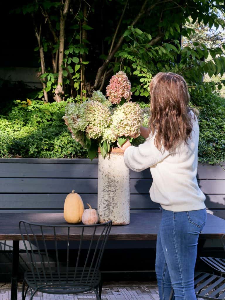 Woman arranging dried hydrangeas.