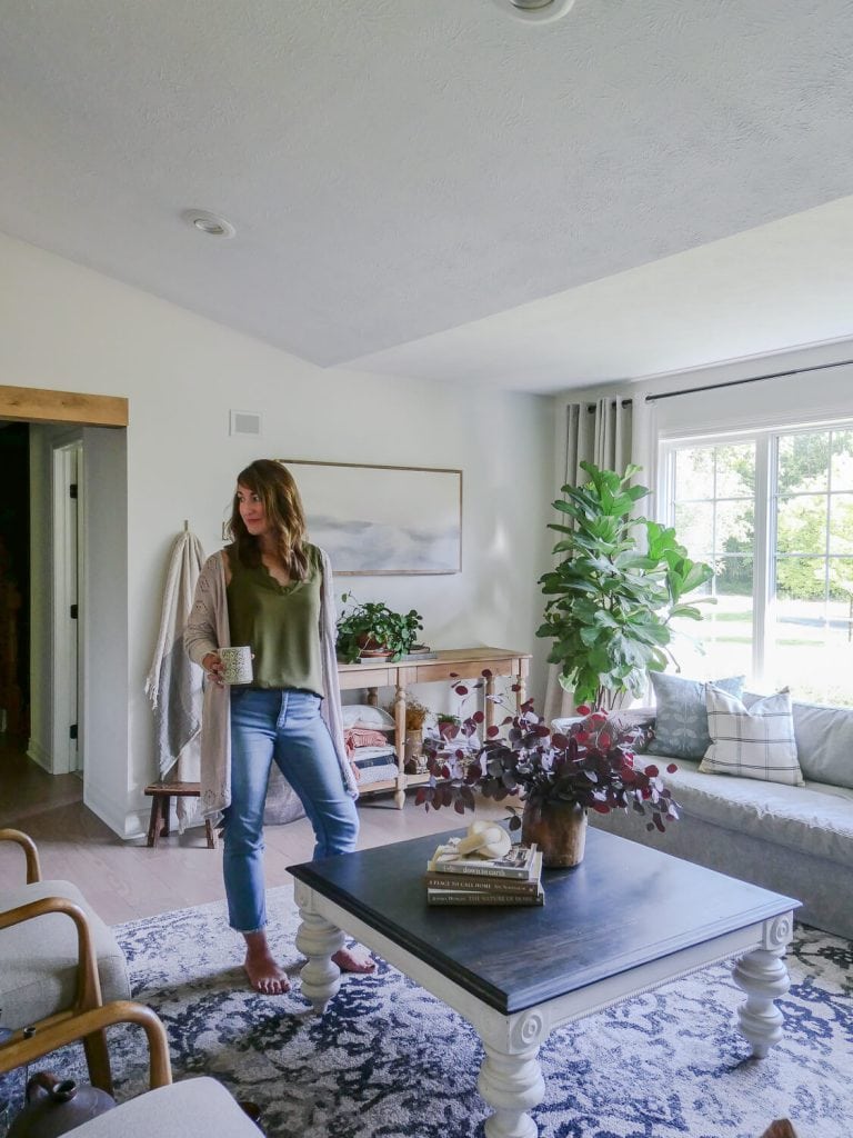 Woman standing in a living room decorated for fall.