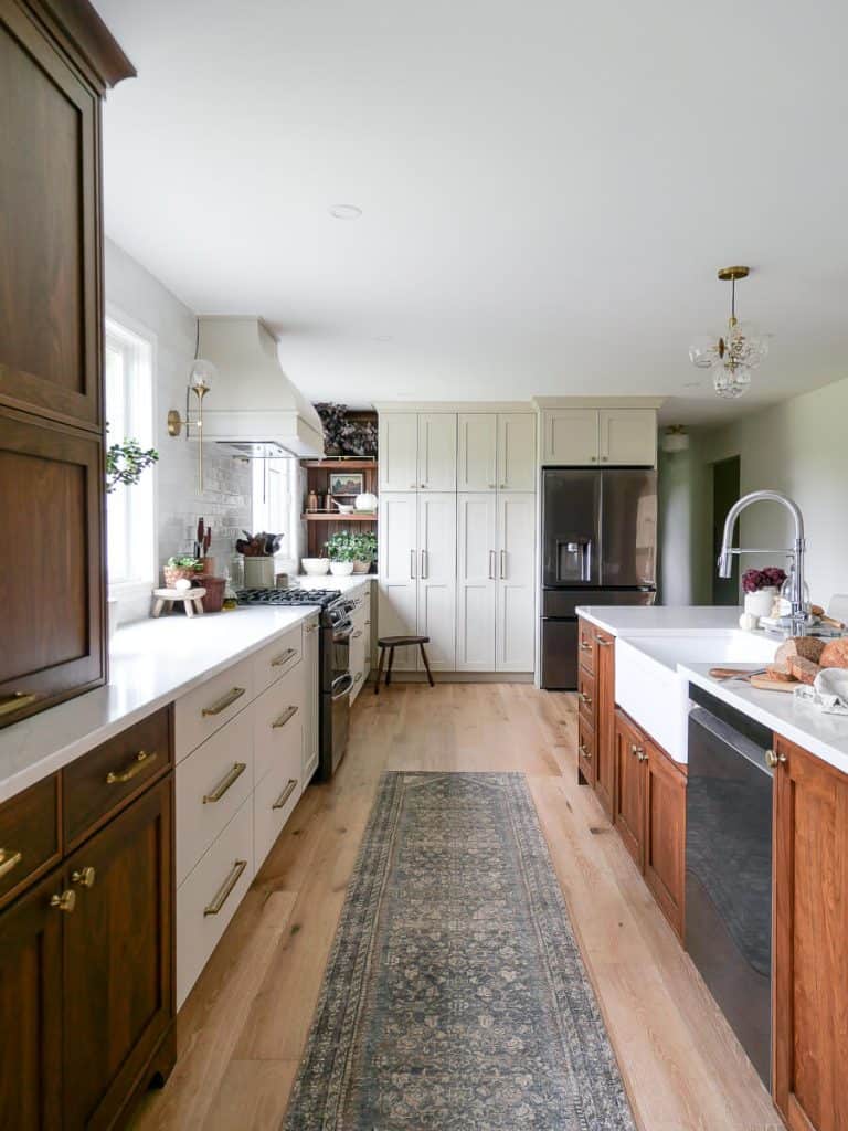 Long view of galley kitchen with island.