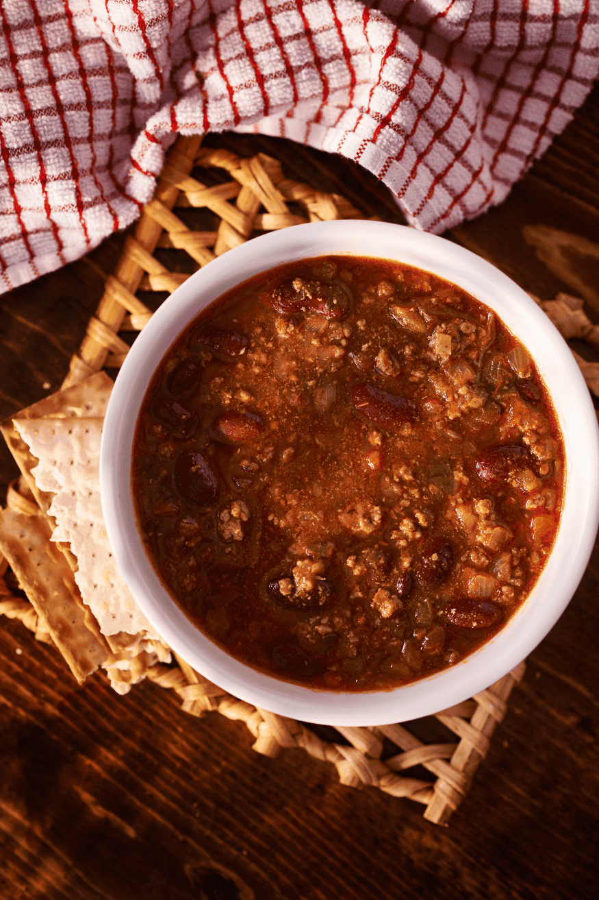 Bowl of chili with plaid towel.