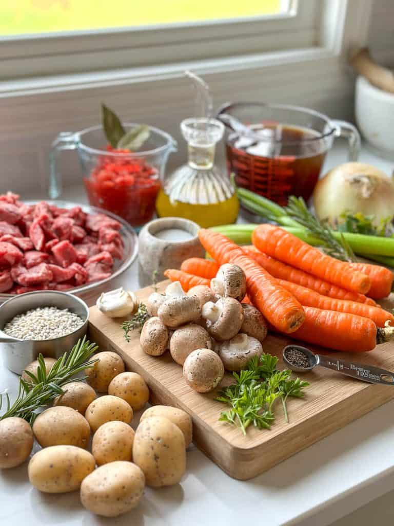 Beef barley stew ingredients on a cutting board.