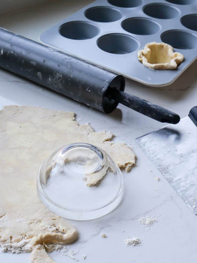 Cutting pie dough into rounds.