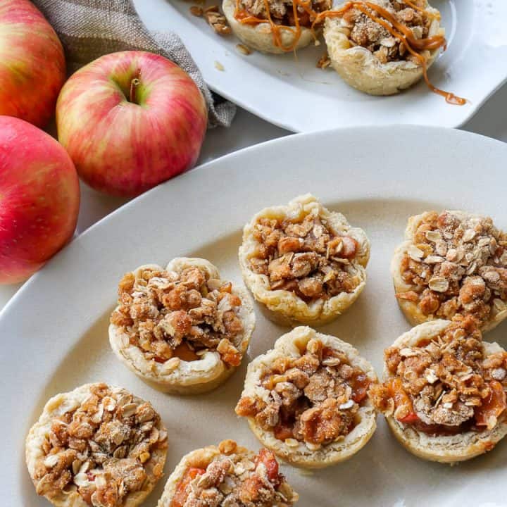 Individual apple tartlets on a platter.