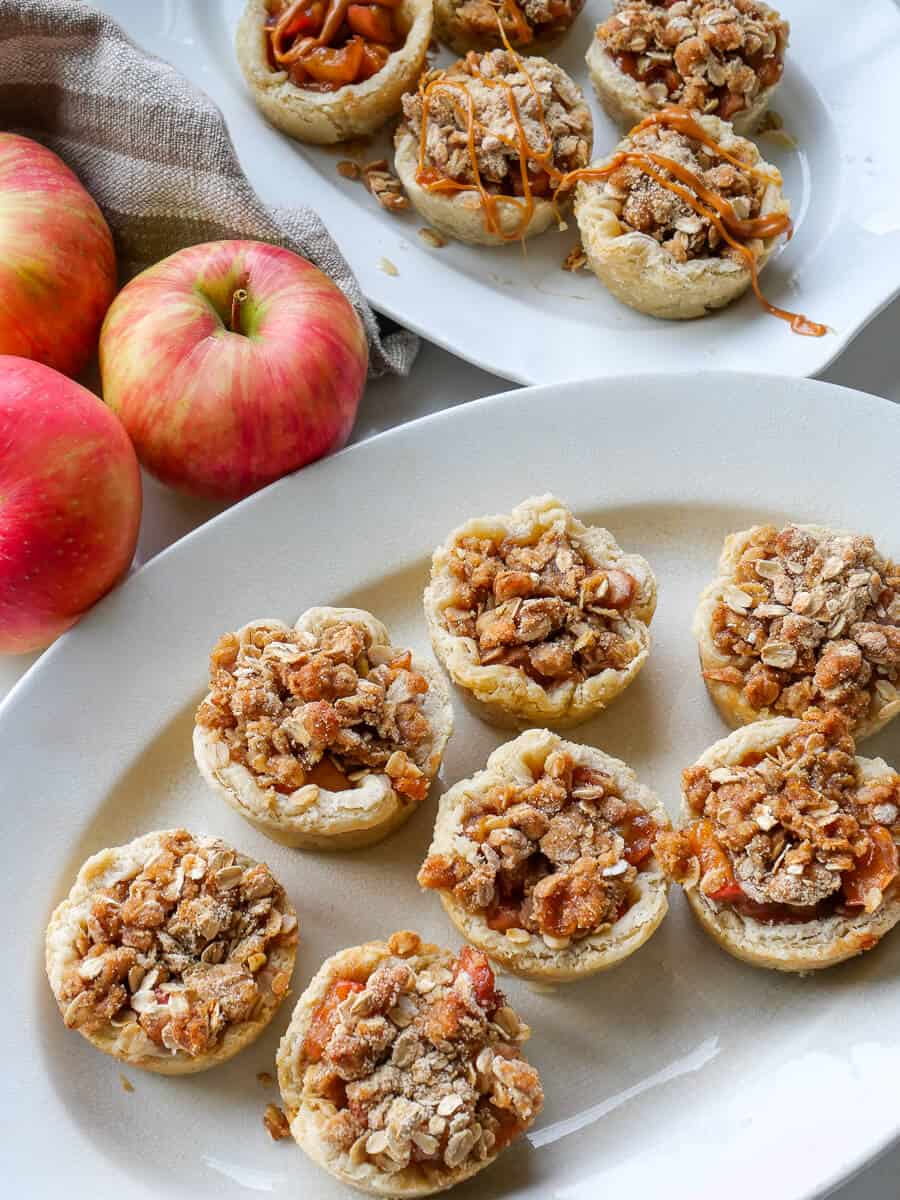 Individual apple tartlets on a platter.