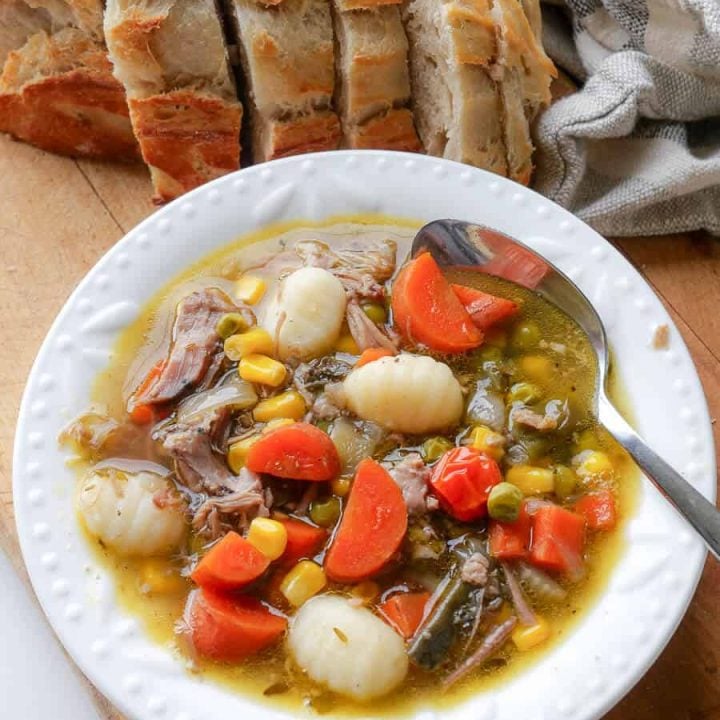 Bowl of pulled pork soup with bread.