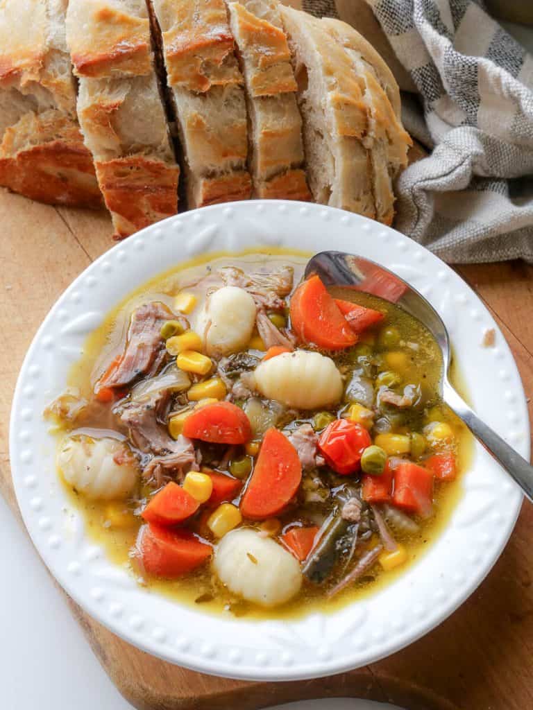 Bowl of pulled pork soup with bread.