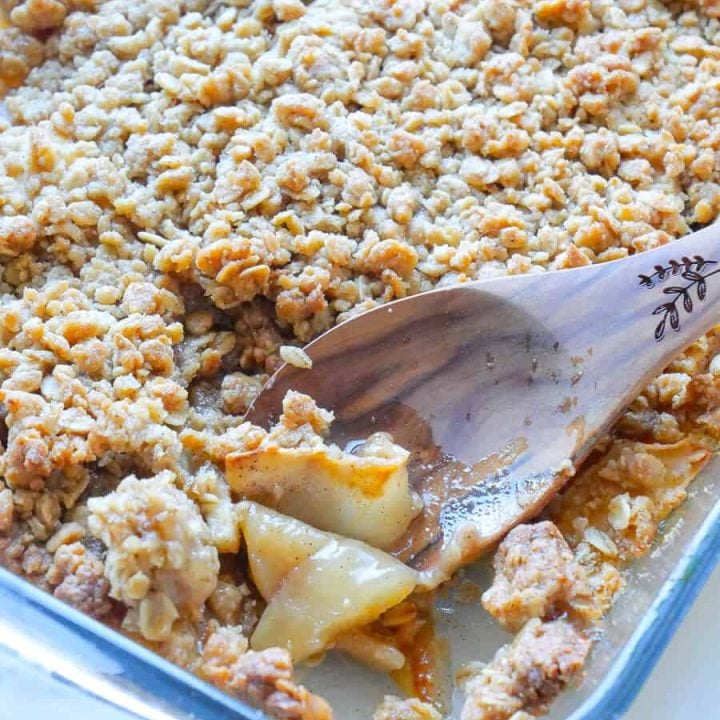 Cinnamon apple crisp being served from a dish.