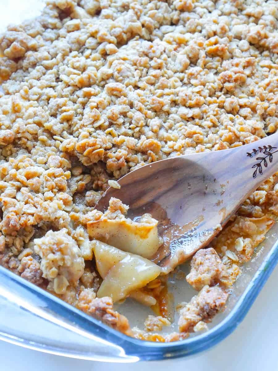 Cinnamon apple crisp being served from a dish.