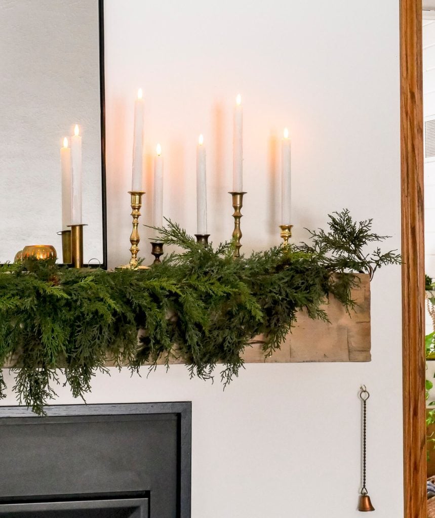 Candles on a simple fireplace christmas mantel.