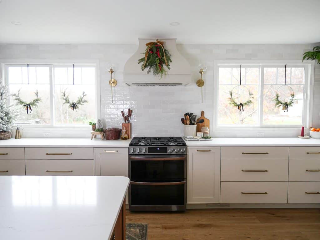 Wide view of kitchen with christmas decorations.