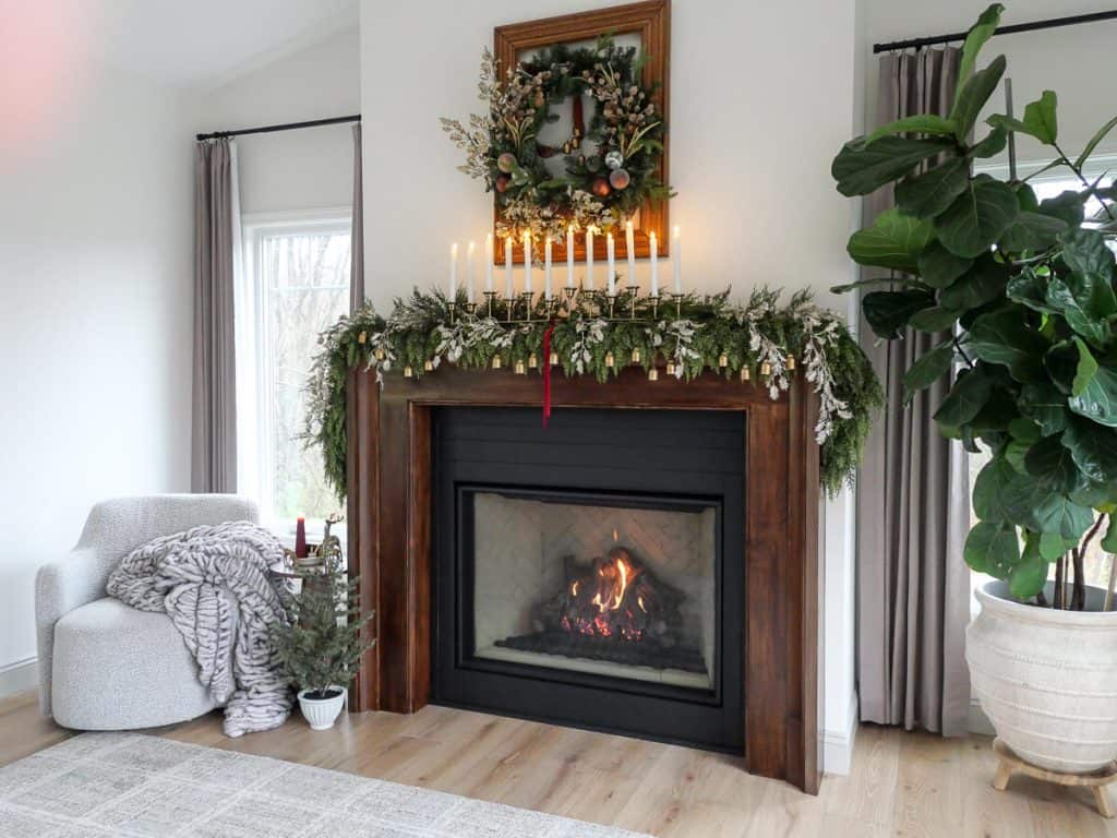 Fireplace mantel with garland draped across.
