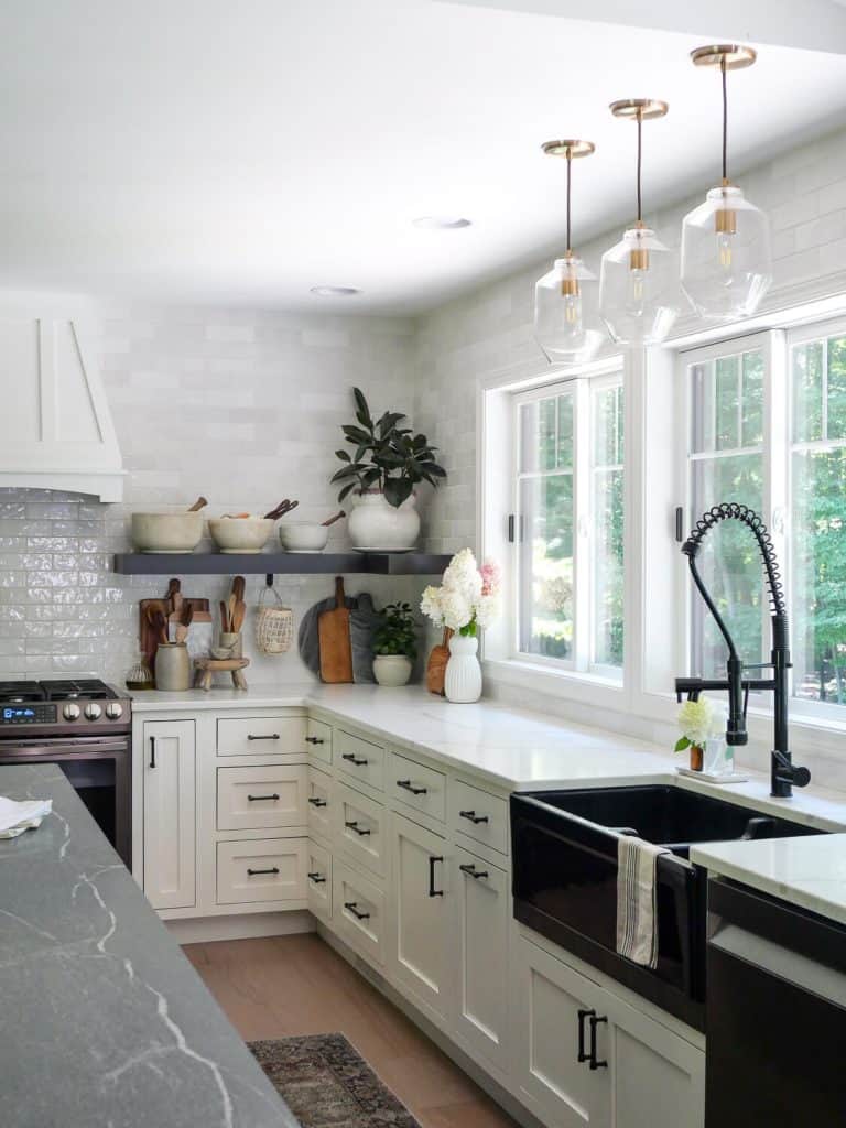 White kitchen cabinets with large window.