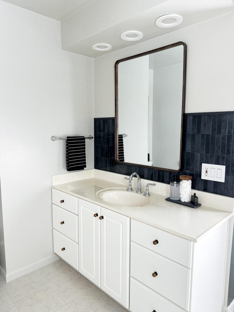 Updated bathroom vanity with bronze mirror.