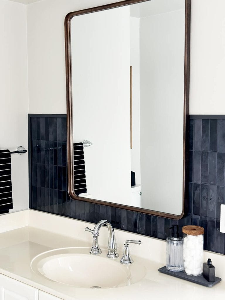 Bronze mirror over black tile.