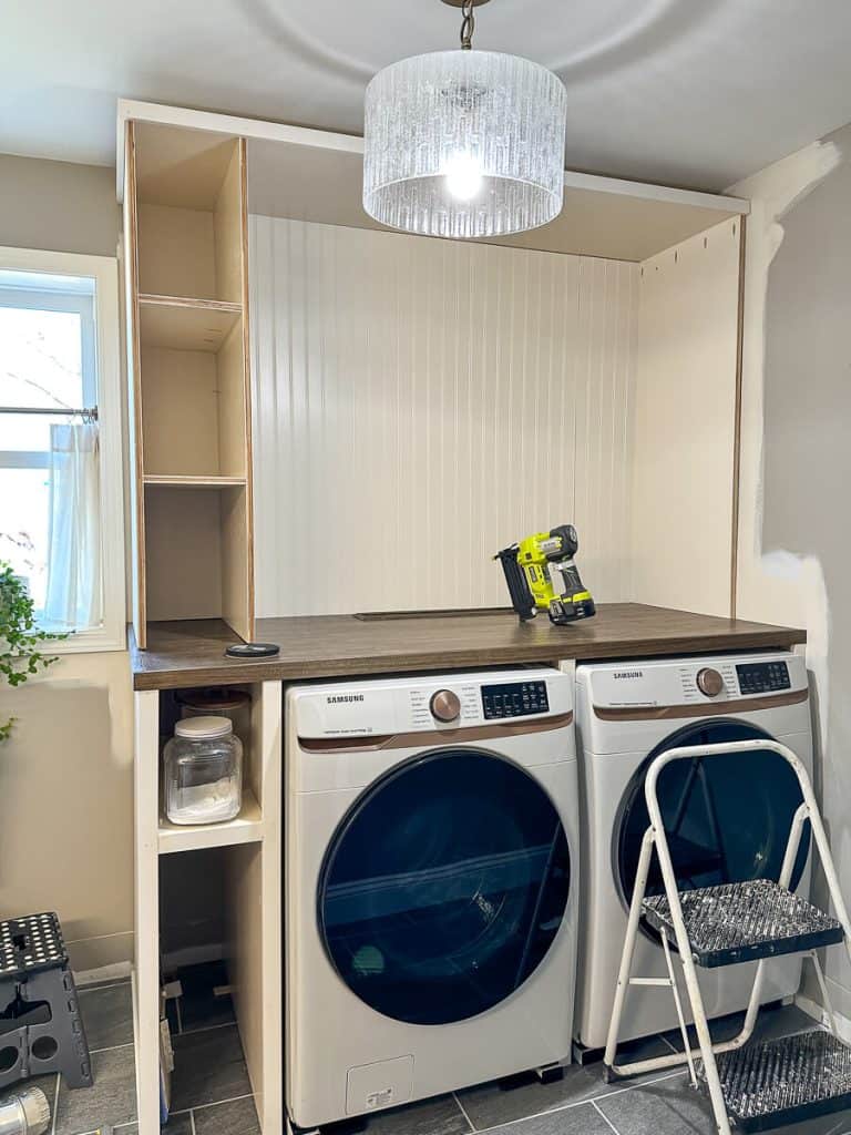 Beadboard hutch top in laundry room cabinet.