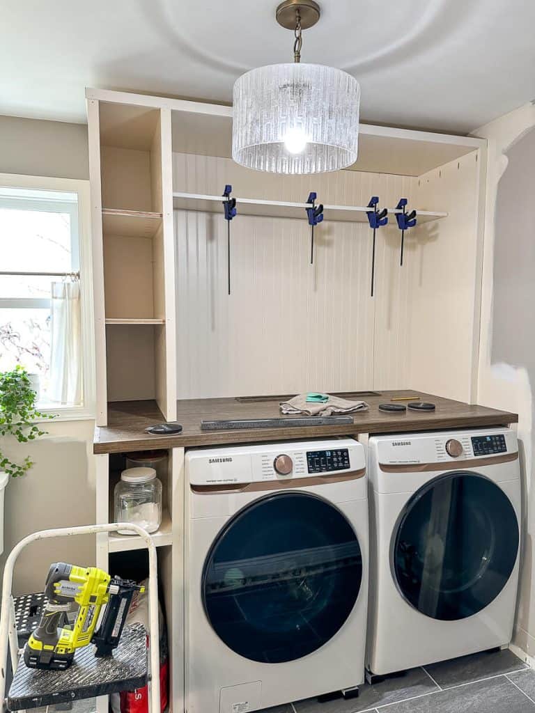 Adding shelf to laundry room cabinet.