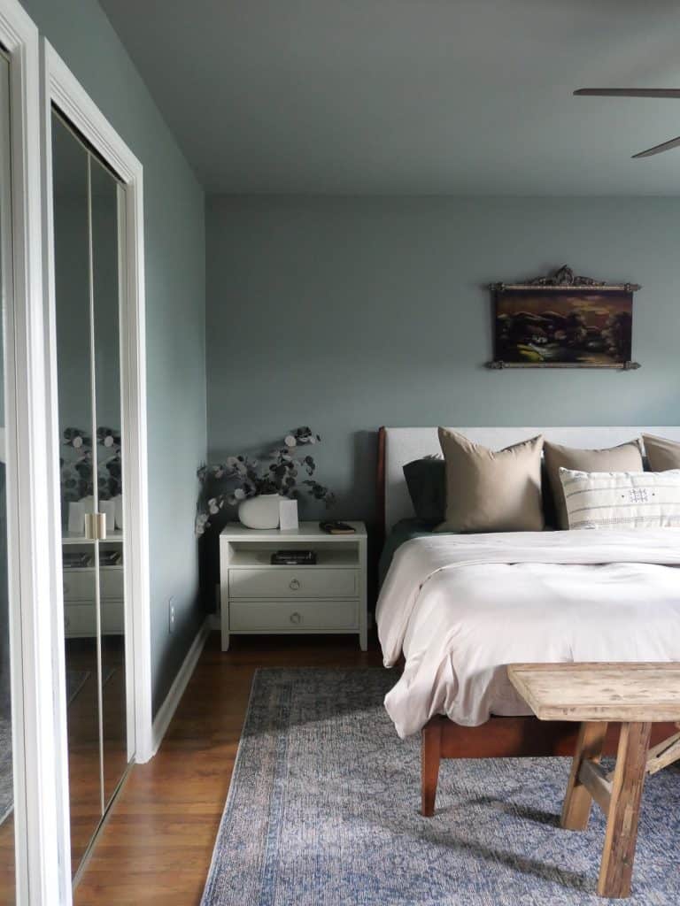 Nightstand in a bedroom with a potted plant and books on top