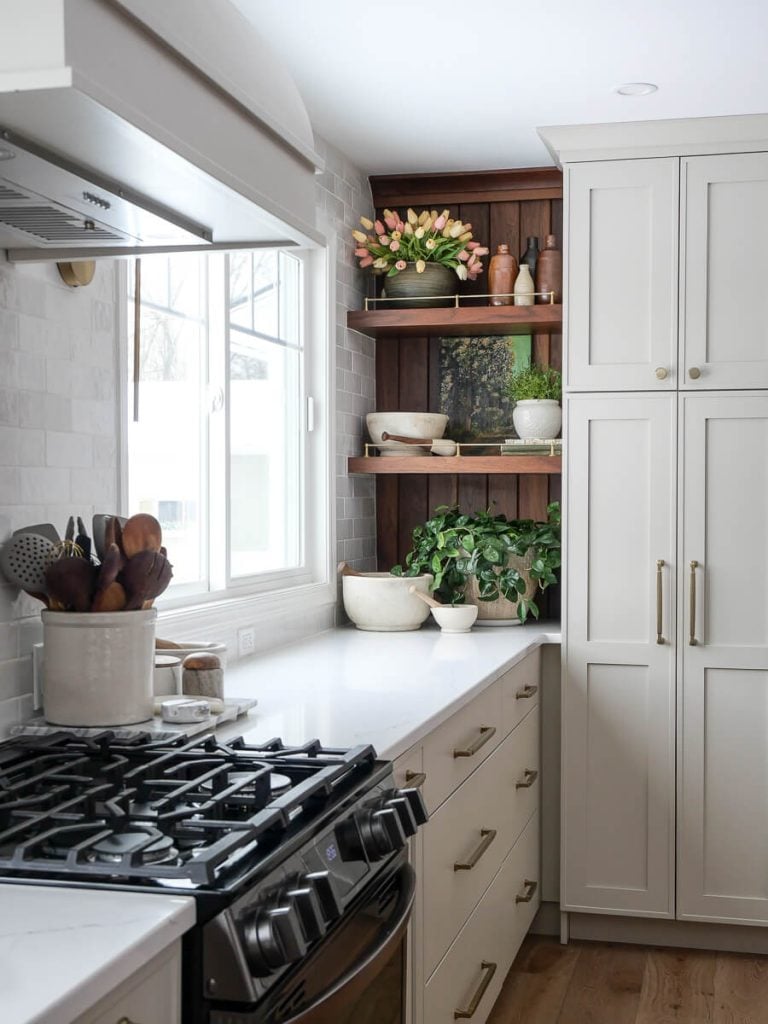 Painted kitchen cabinets with walnut shelving.
