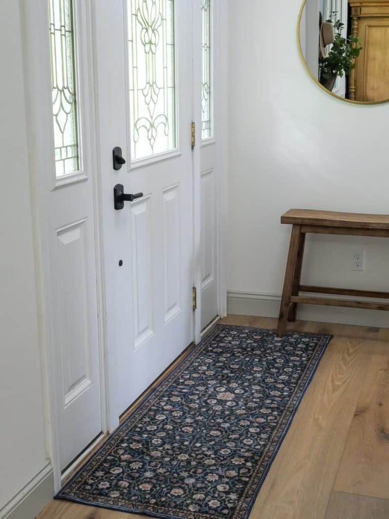 Front entry with a bench and rug.