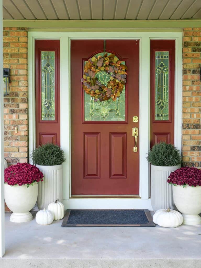 Fall front porch ideas with a red door.