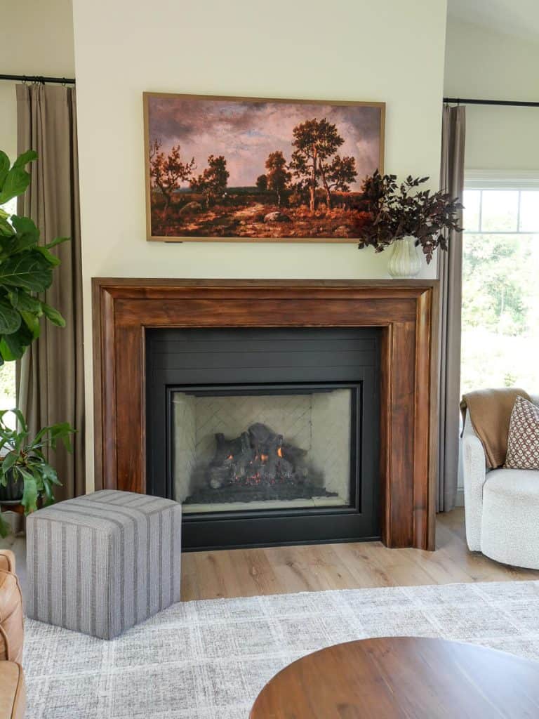 Fall foliage in a vase on a living room mantel styled for fall.