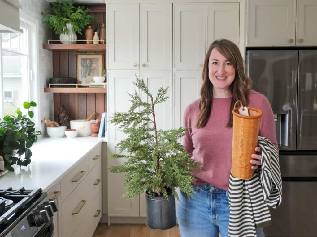 Woman holding thrifted items for Christmas.
